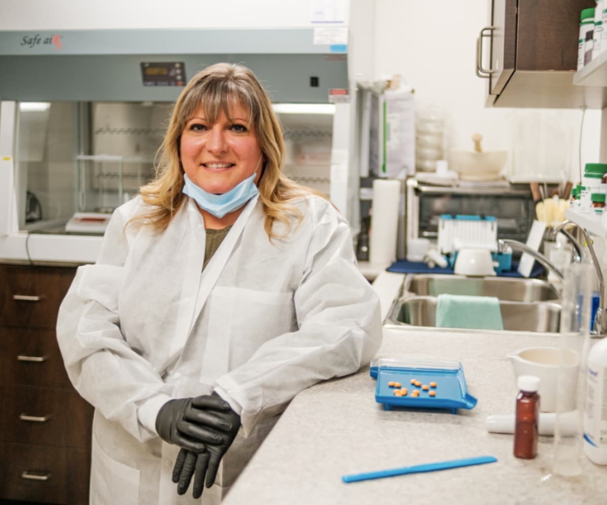 Pharmacist in a compounding lab preparing medication with professional equipment