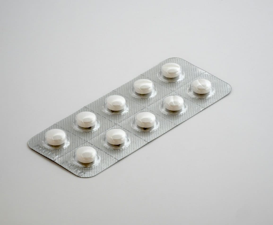 Blister pack of white tablets on a grey surface