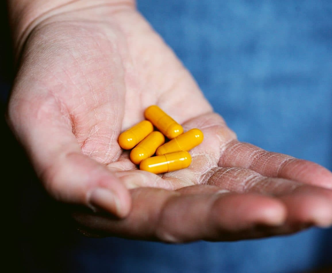 Yellow capsules resting in an open hand